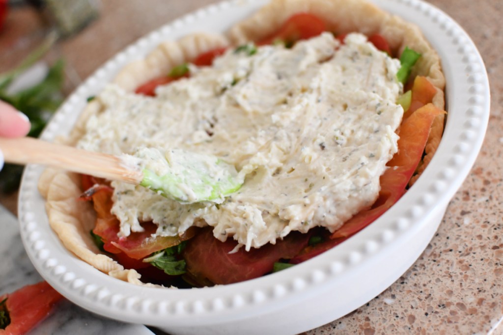 adding mayo and cheese to tomato pie