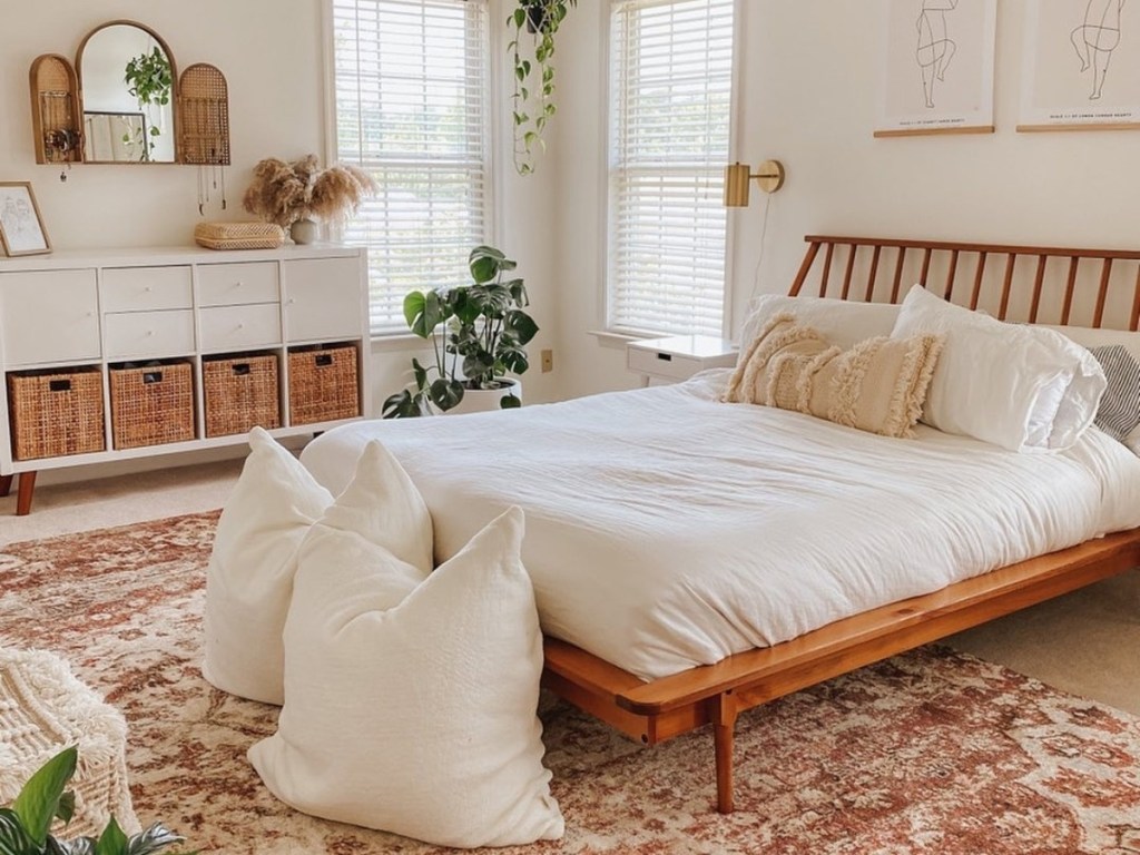 white bedding on bed in bedroom decorated in neutral tones