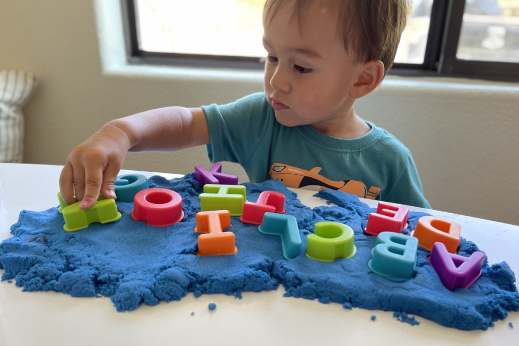 boy playing letters in kinetic sand 