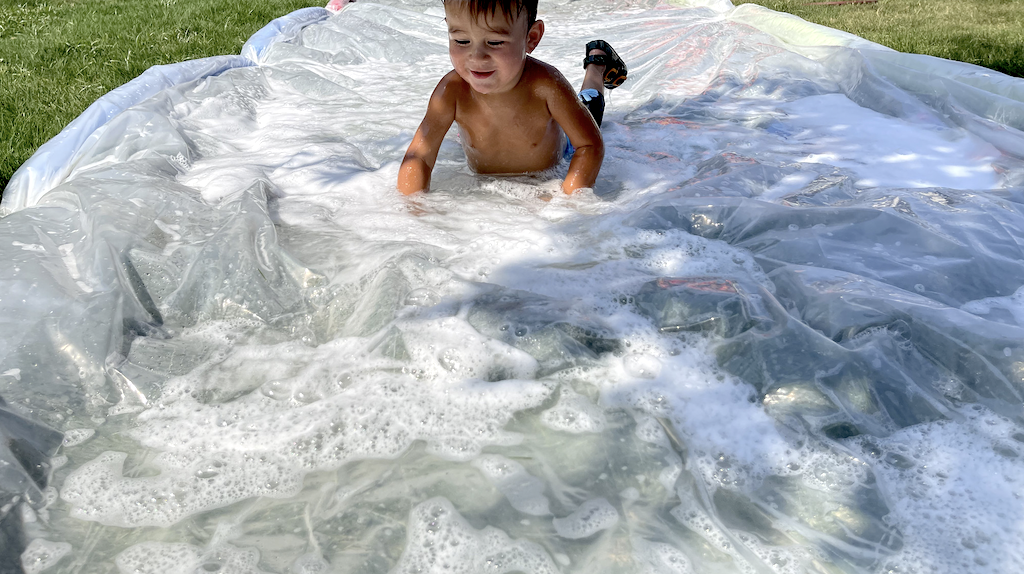 little boy on DIY slip and slide 