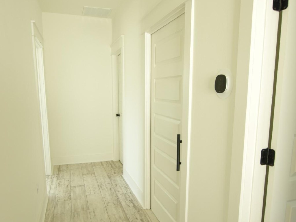 well lit hallway showing thermostat on wall