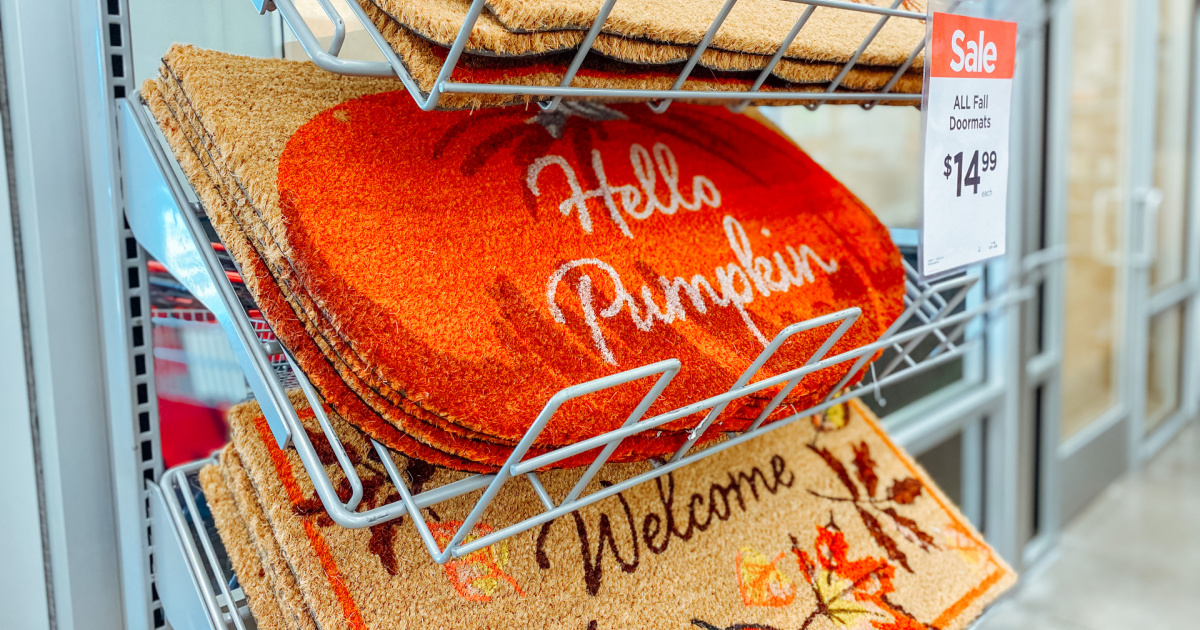 doormat with an orange pumpkin that says hello pumpkin on display in a store