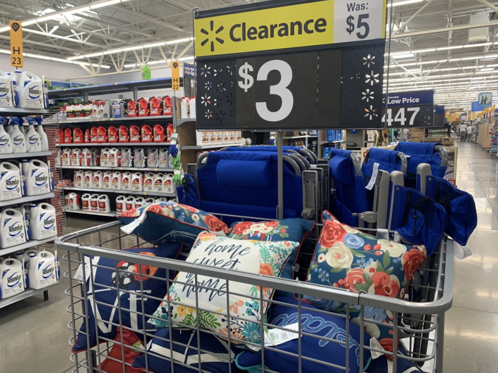 store display with outdoor throw pillows and price sign