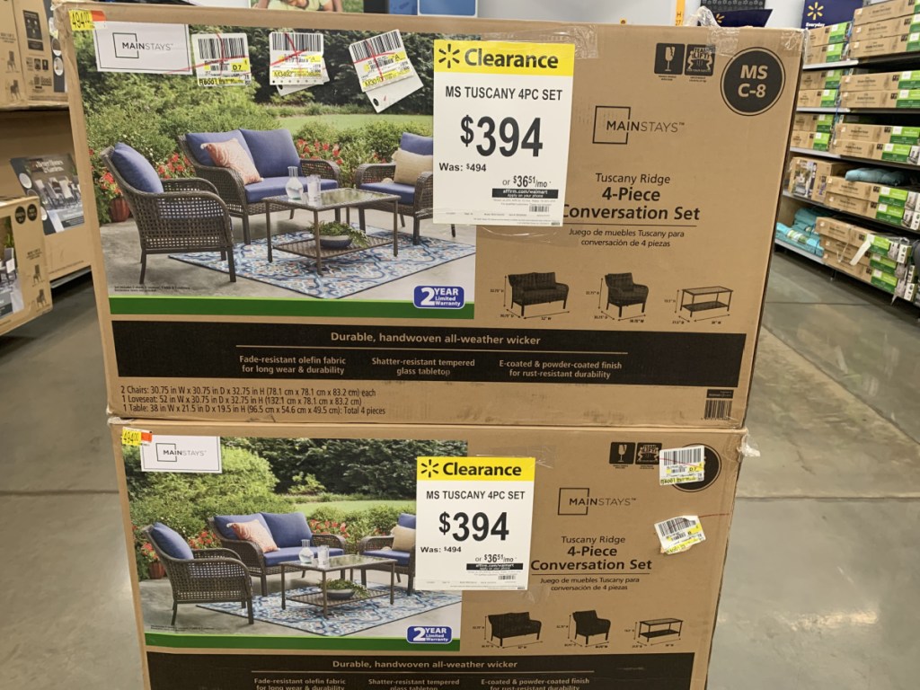 2 boxes with outdoor patio sets in them on store showroom floor