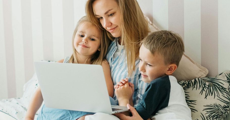 Mom and two kids looking at the screen on a laptop