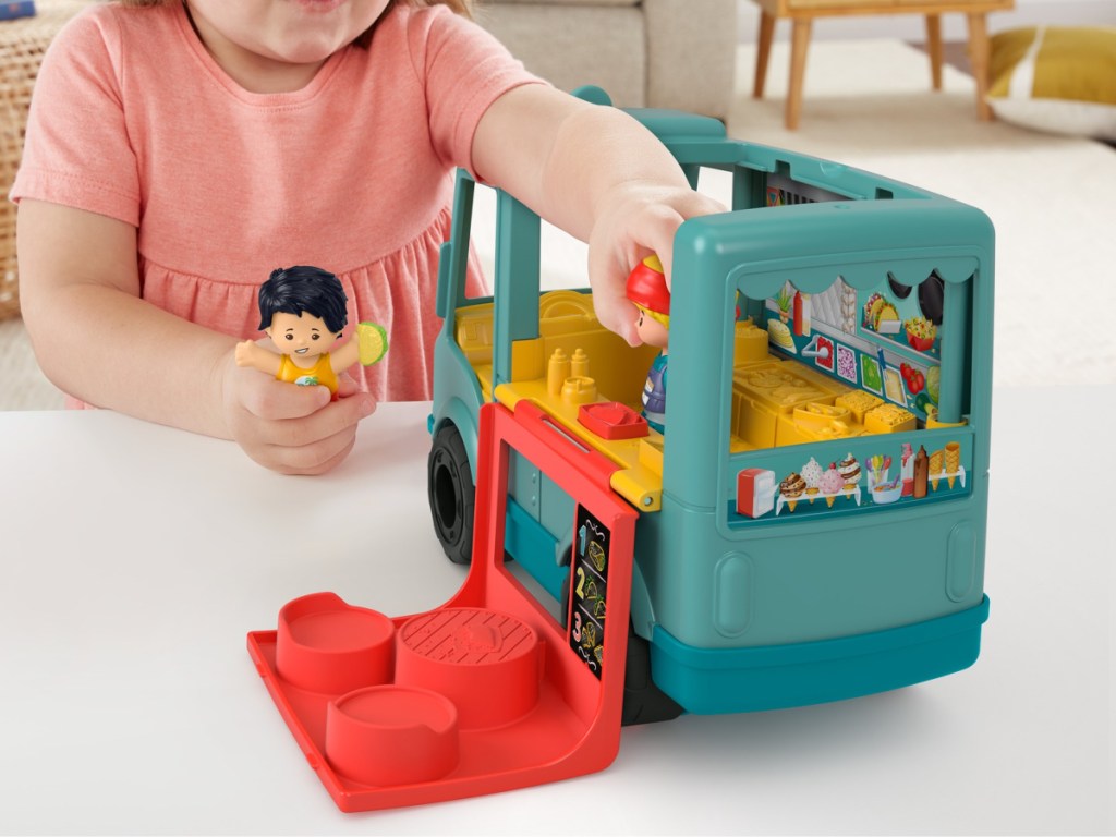 child playing with toy food truck