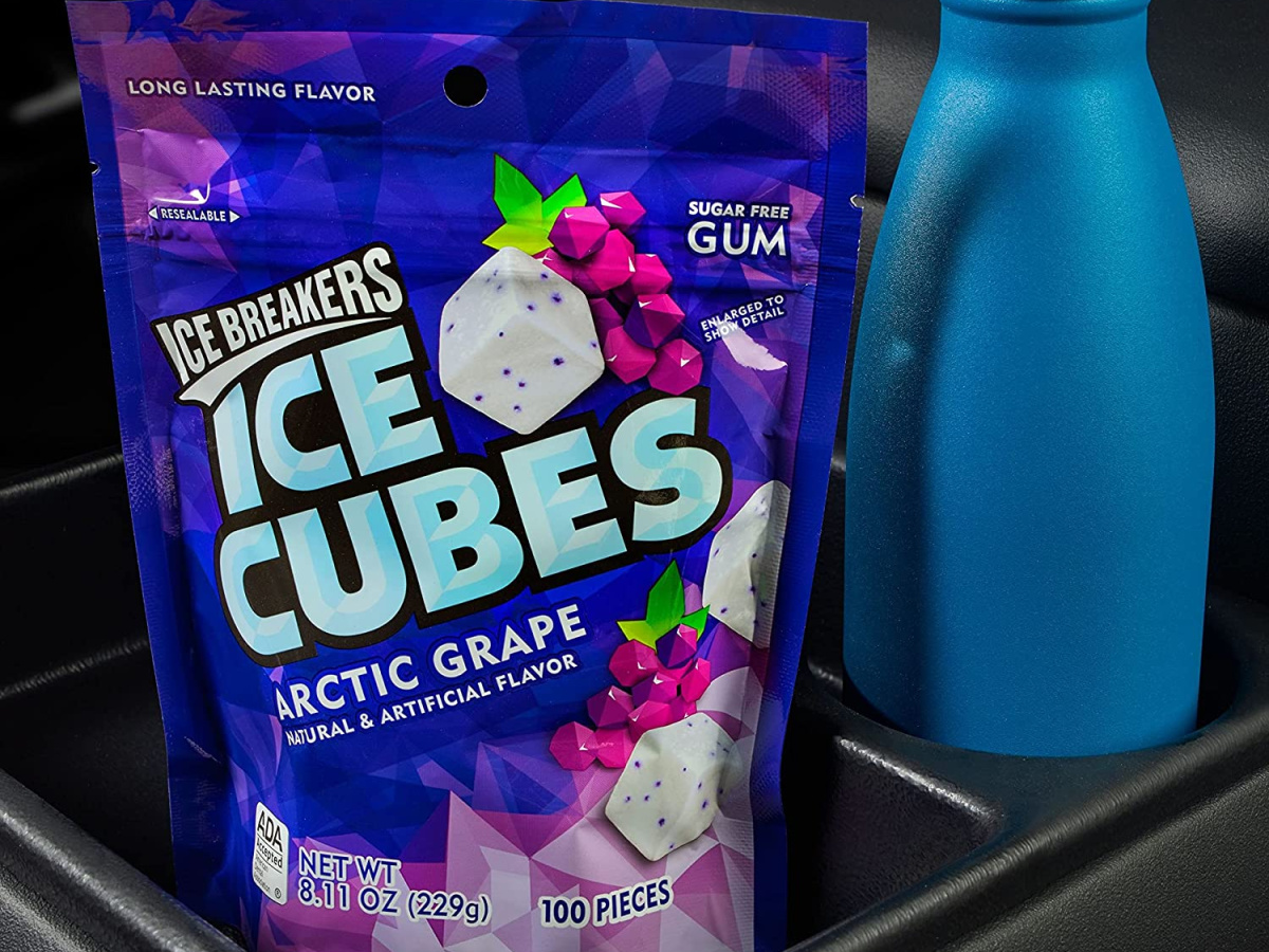 bag of grape gum cubes and blue tumbler in car