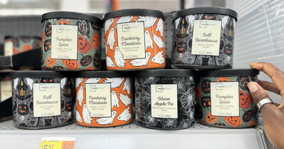 hand touching stack of halloween candles on store shelf