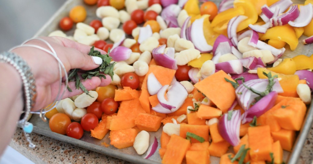 adding fresh sage to sheet pan gnocchi