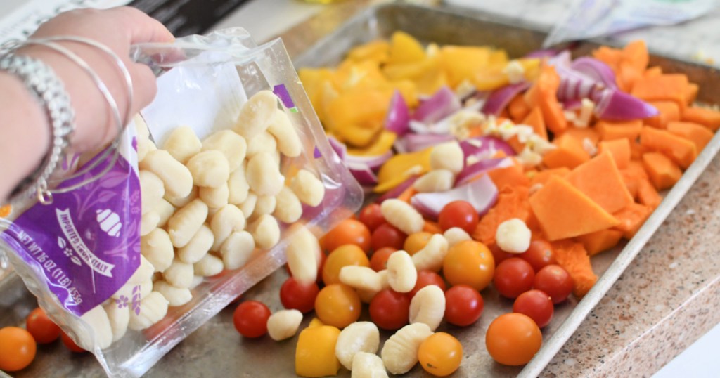 adding prepared gnocchi to sheet pan