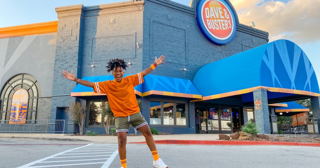 woman standing outside of dave and busters sports bar restaurant 