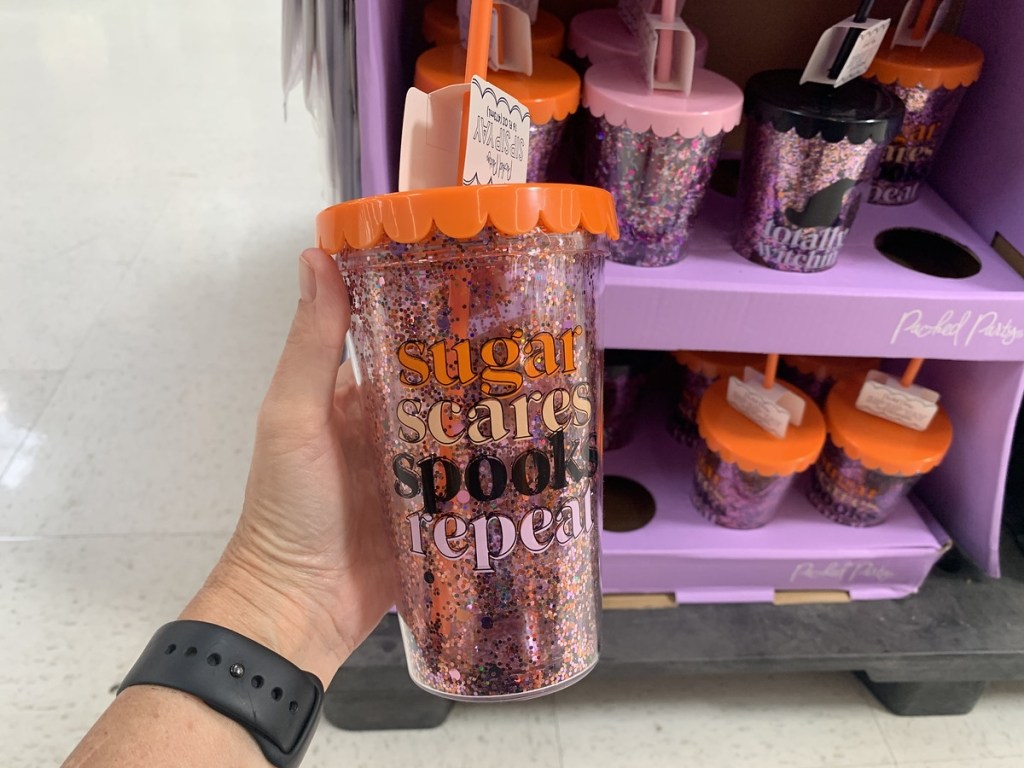 holding a Halloween tumbler