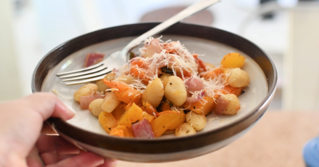 holding a bowl of gnocchi pasta