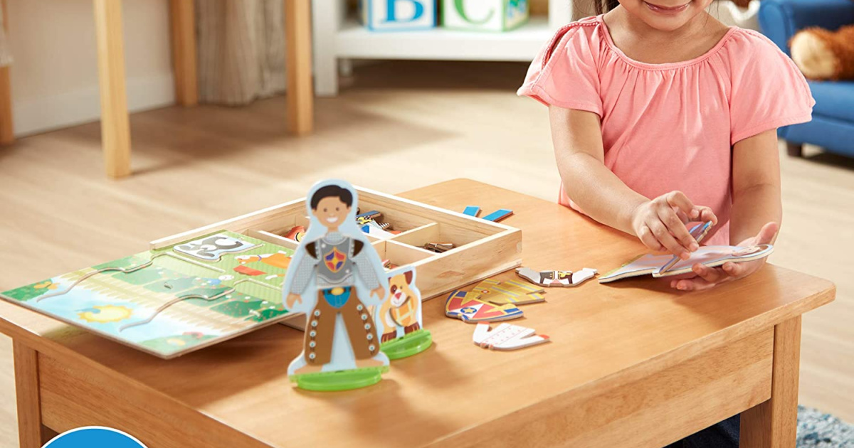 girl playing with a melissa doug magnetic dress up dolls set on a table