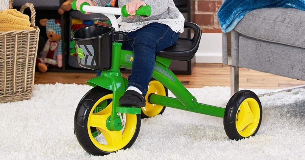 young girl riding john deere pedal tricycle