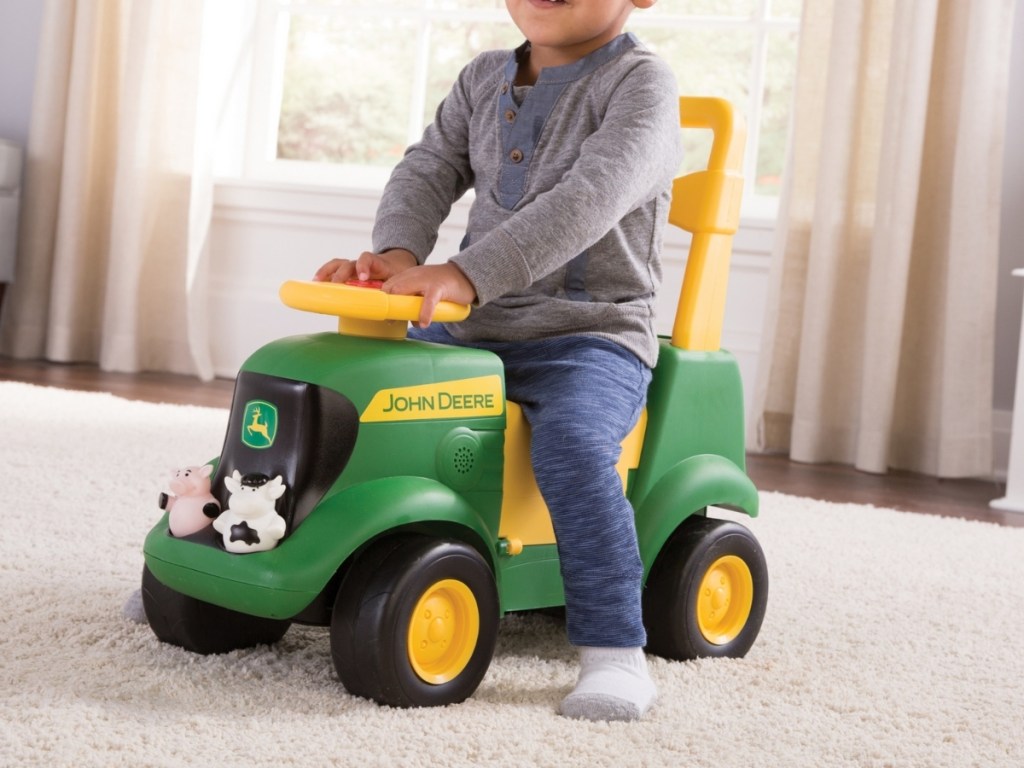 young boy on john deere sit 'n scoot