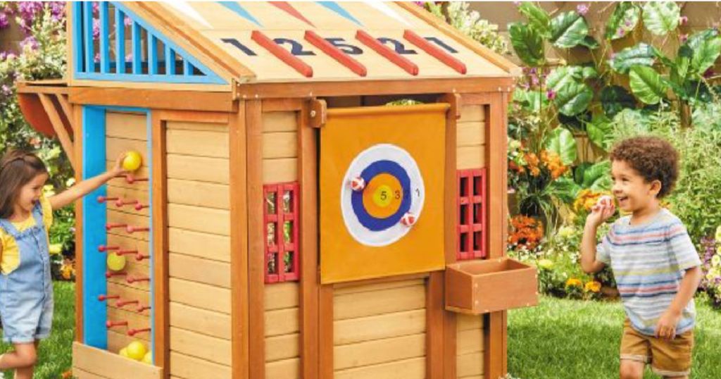 kids in front of wooden toy house 