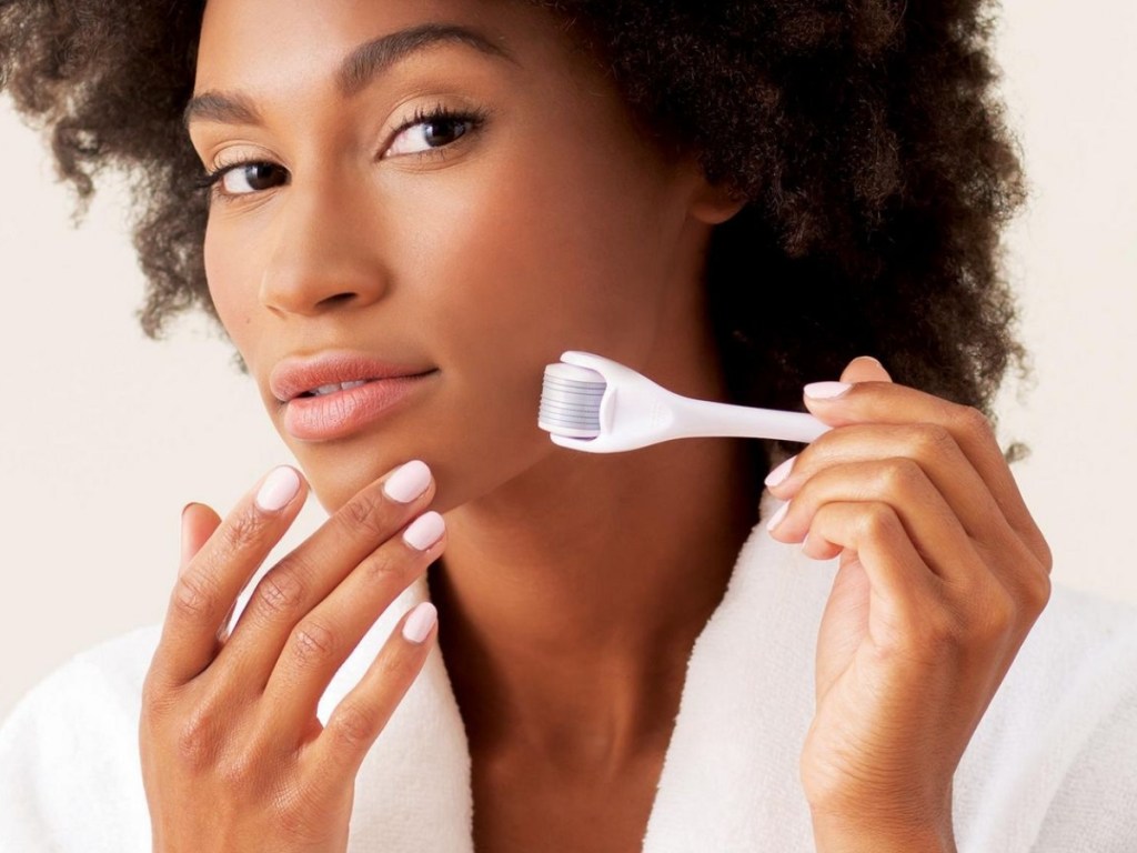 woman using plum beauty facial roller