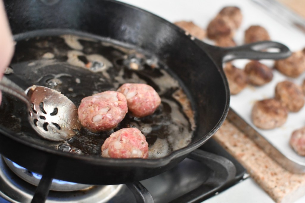 frying meatballs and placing on baking sheets