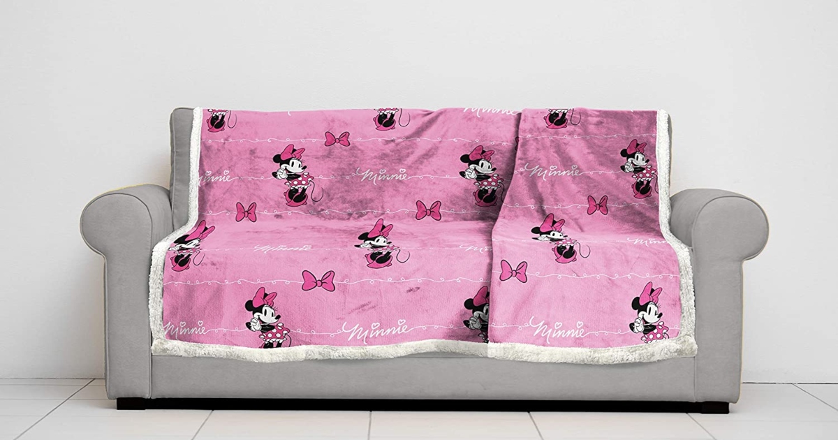 Pink Minnie Mouse Sherpa blanket layed out on a couch