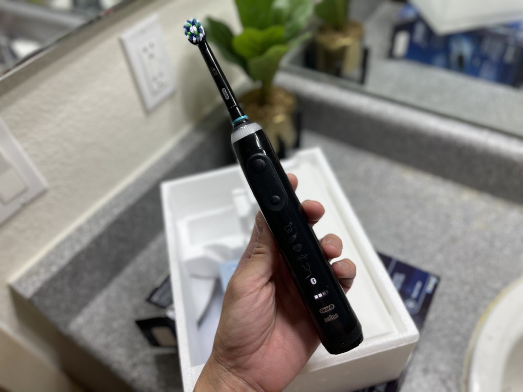 oral B electric toothbrush in hand