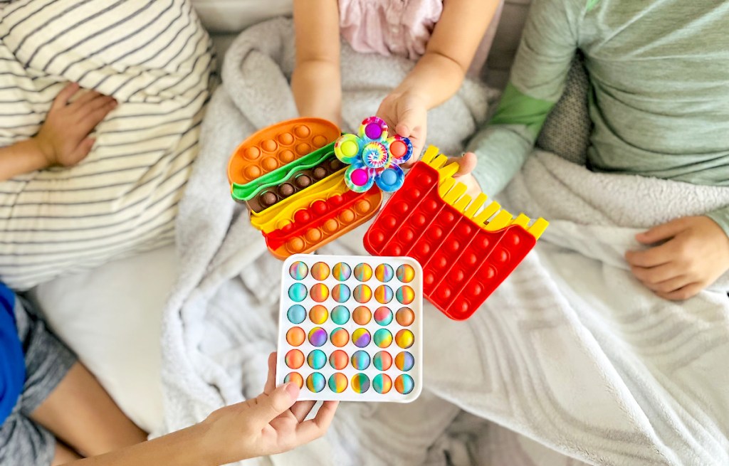 kids holding different kinds of colorful pop it fidget toys