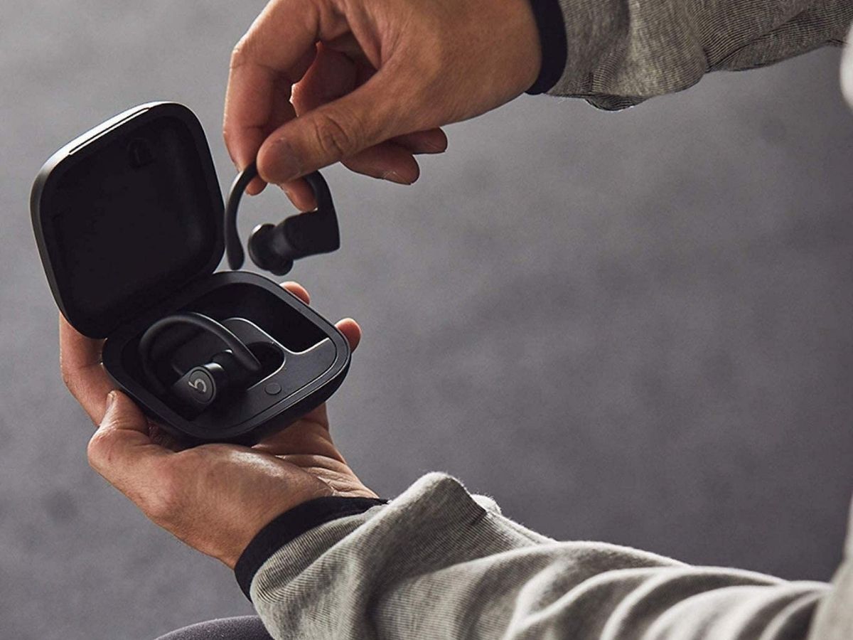 man taking black beats earbuds out of case