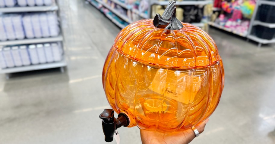 hand holding orange glass pumpkin