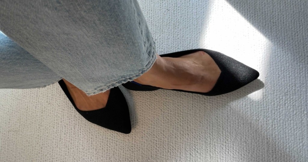 wearing a pair of black pointed-toe flats