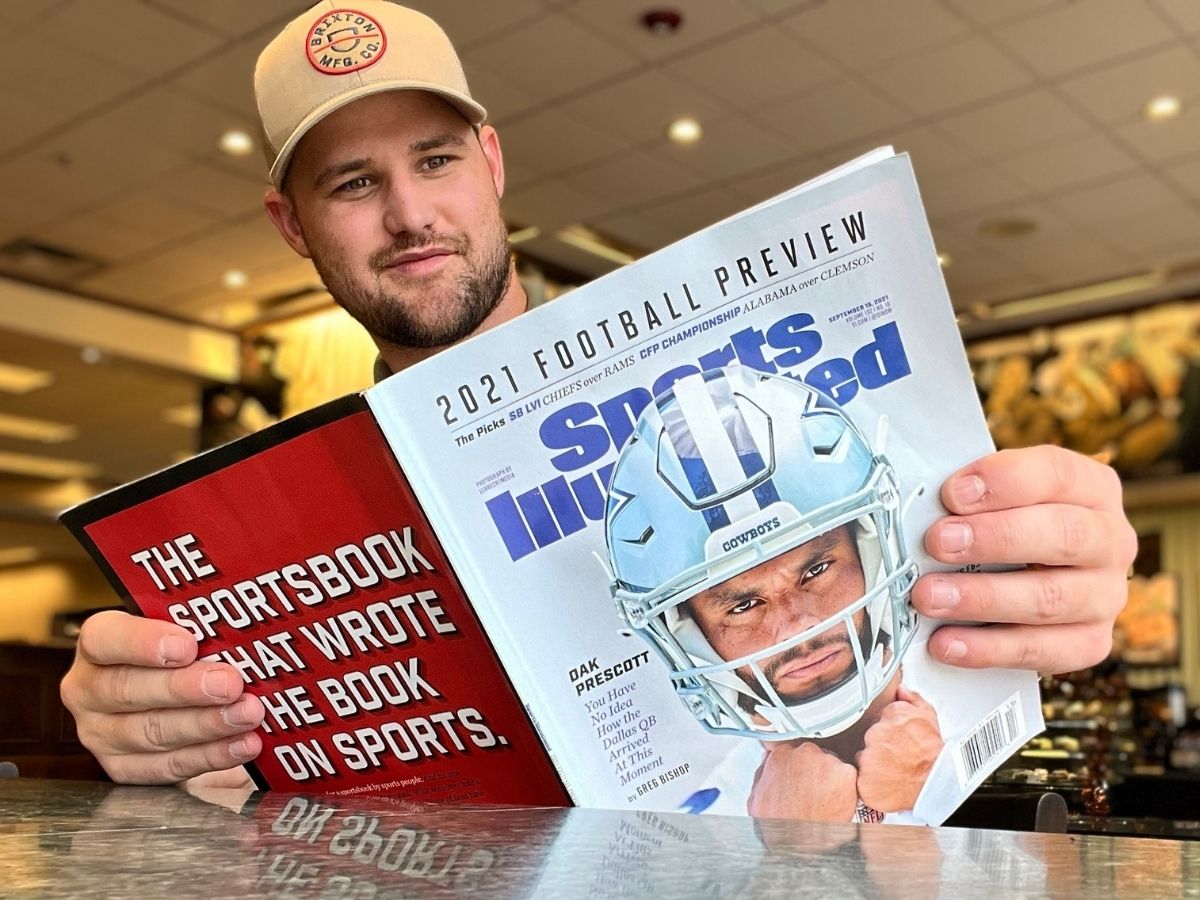 man reading sports illustrated