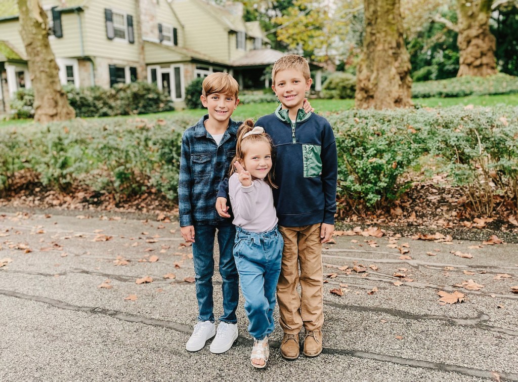 three kids standing together in street