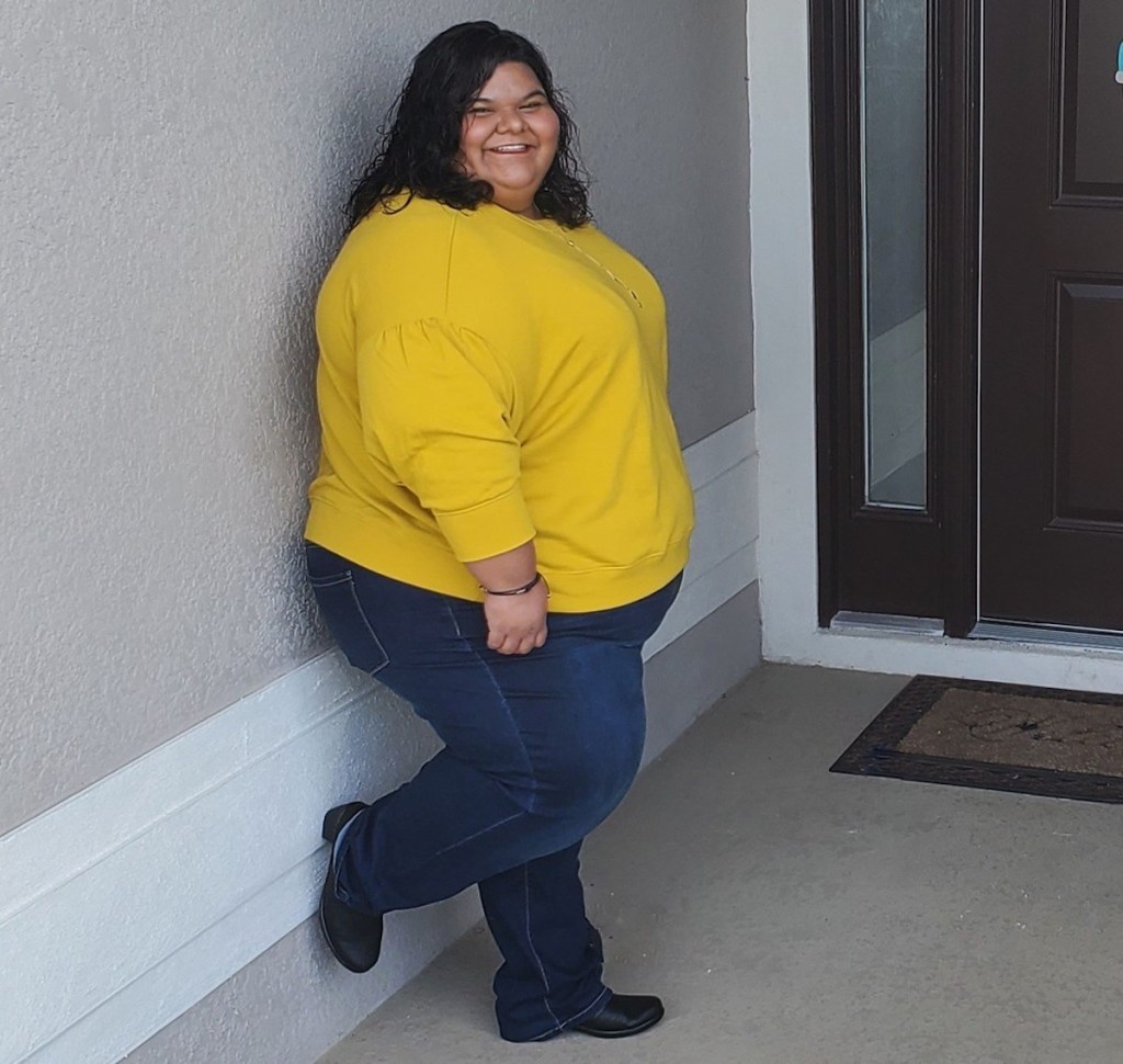 woman leaning against wall showing off walmart winter fashion outfit