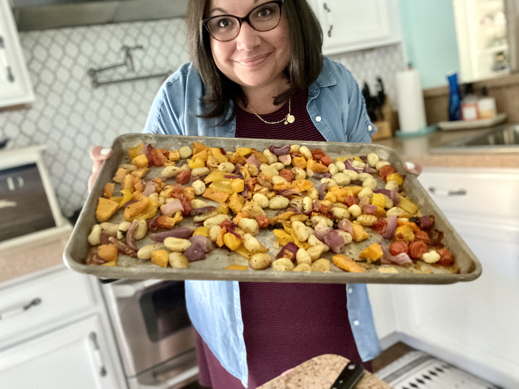 woman holding meatless sheet pan meal