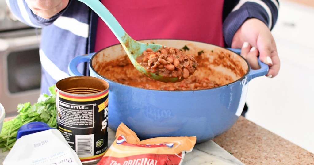 woman stirring ranch style chili