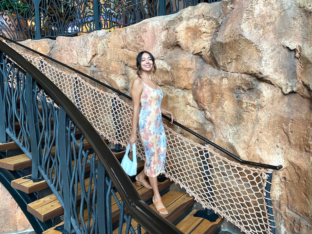 woman walking down stairs wearing Shein dress and purse 