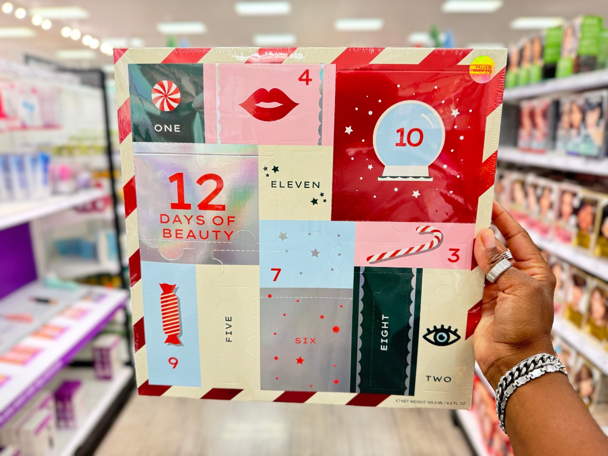 hand holding a 12 Days of Beauty Advent Calendar Box in a store aisle with holiday and beauty images on the front