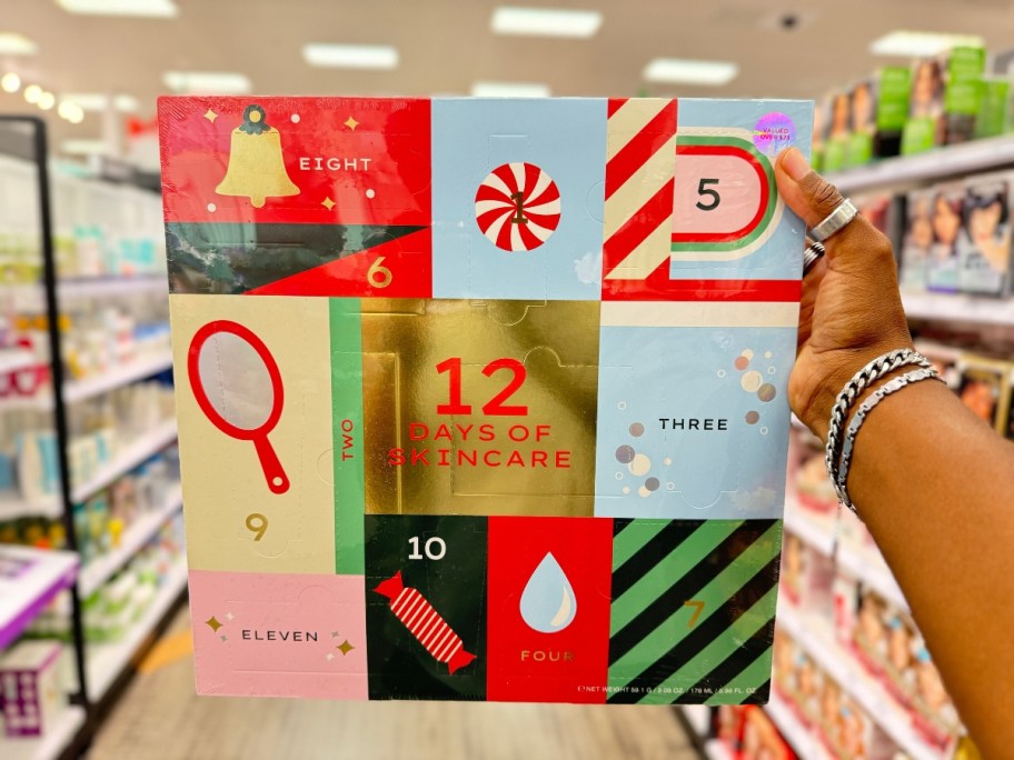 hand holding a 12 Days of Skincare Advent Calendar Box in a store aisle with holiday and skincare images on the front