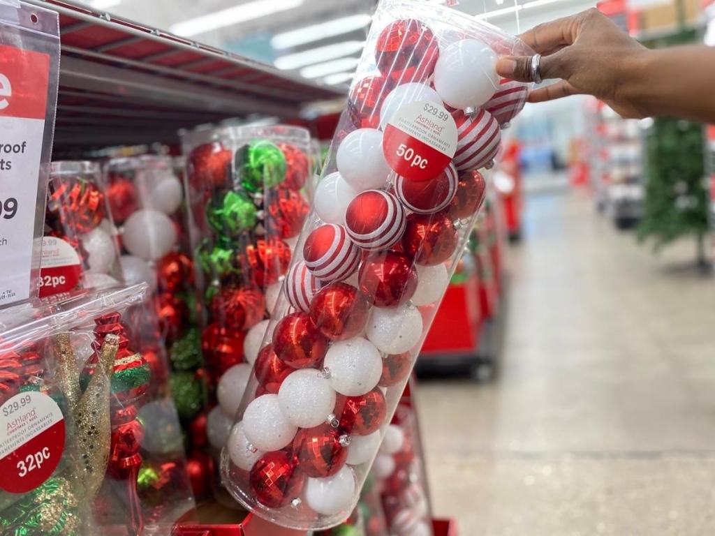 hand holding ashland red and white ball ornaments in store