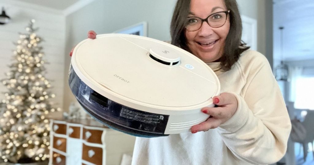 woman holding white robot vacuum