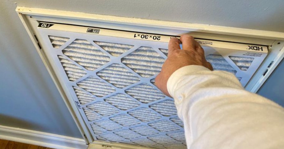 man changing hdx air filter in home