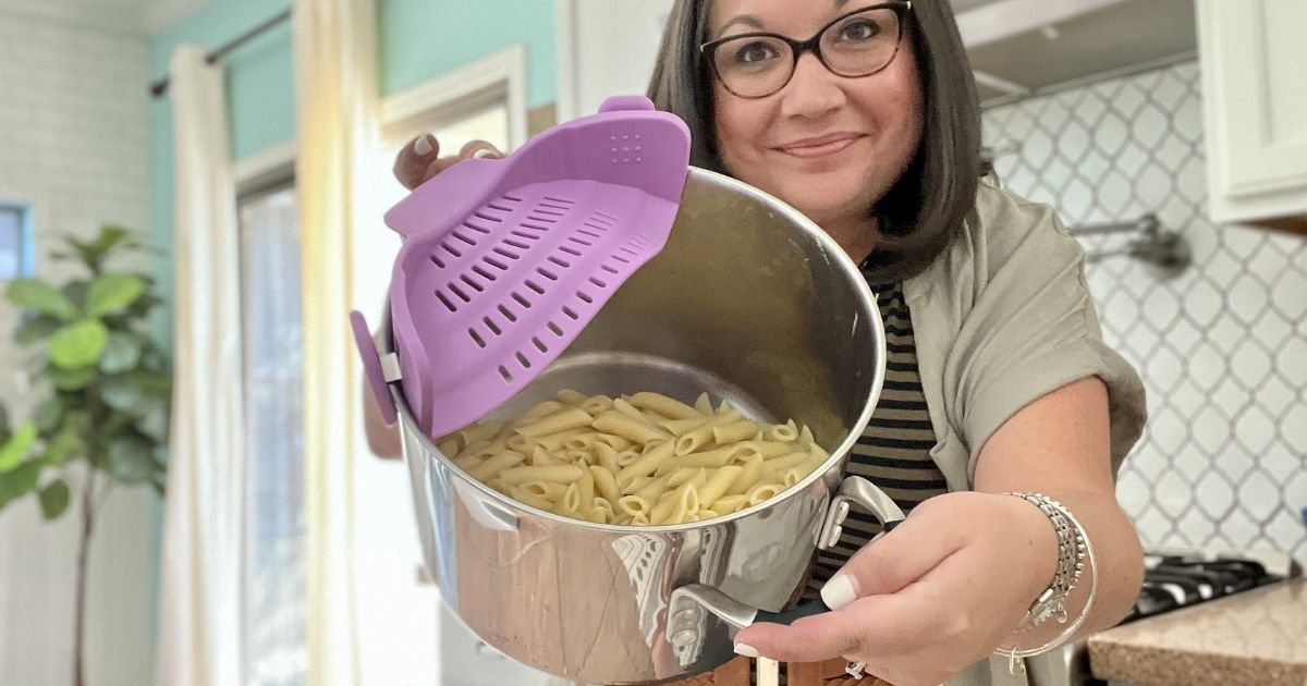 woman with a pot of noodles and purple strainer