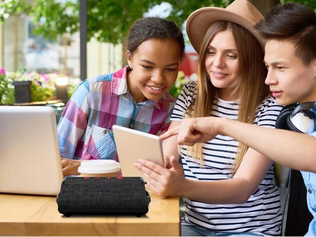 kids looking at tablet with speaker on table