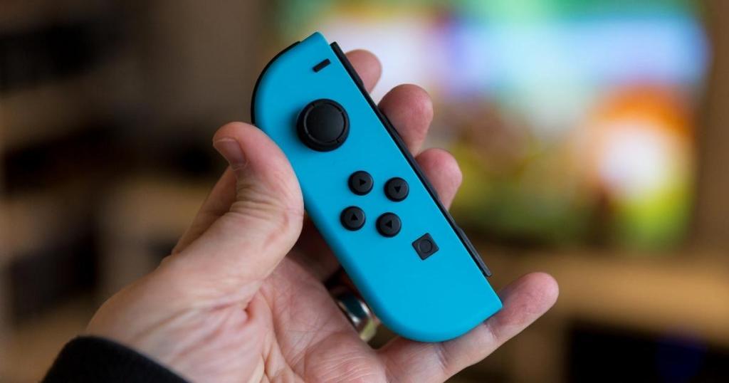 hand holding nintendo switch blue joy con controller