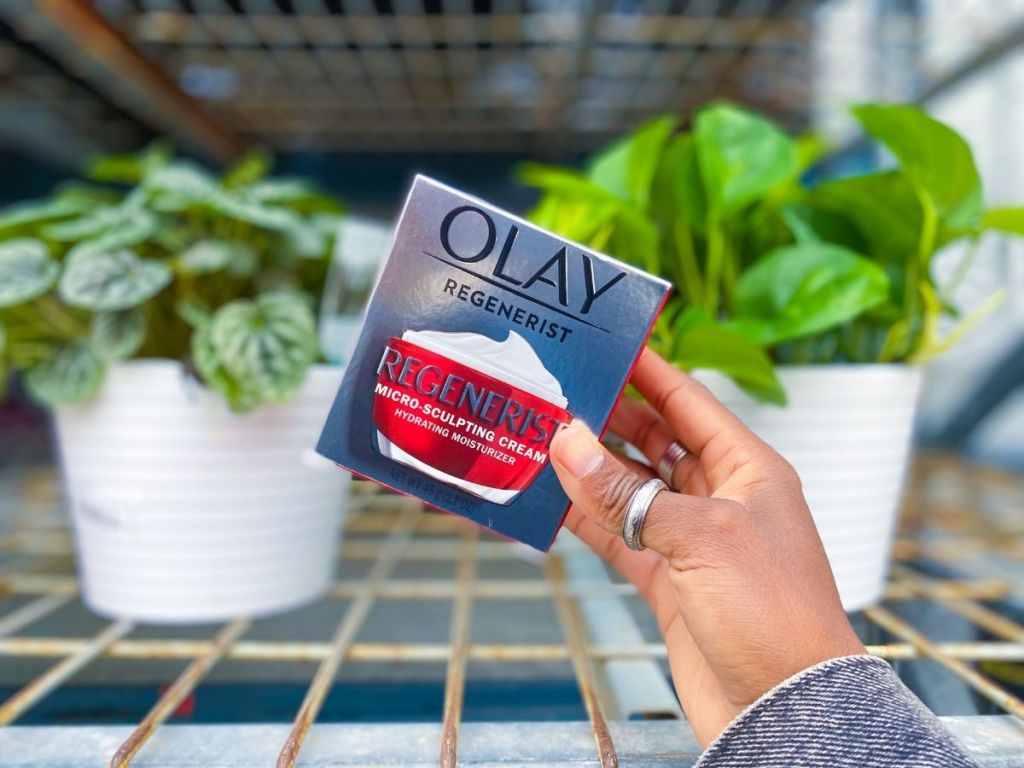 holding Olay face cream