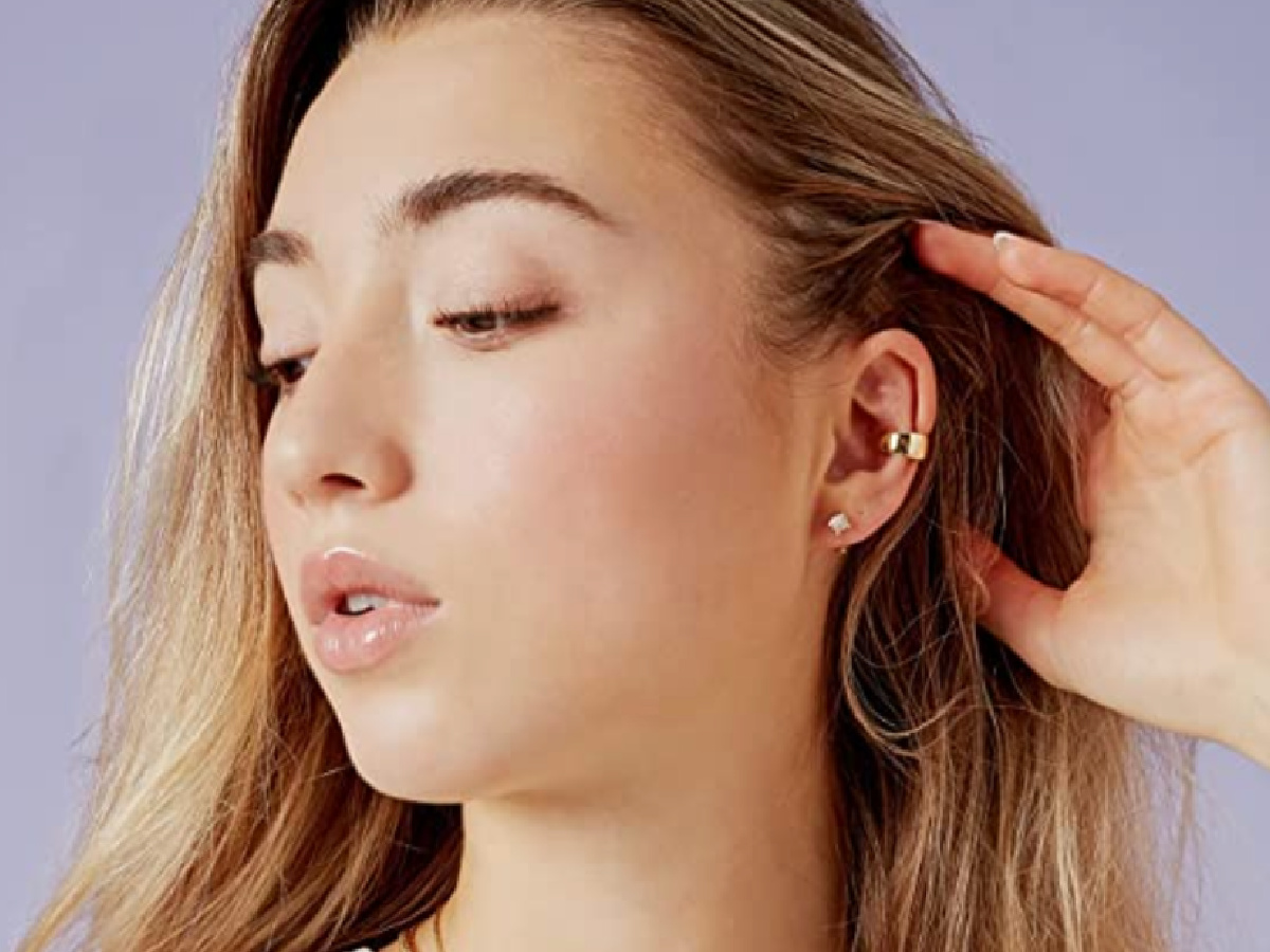 woman holding back her hair exposing her ear and showing the PAVOI jewelry she's wearing