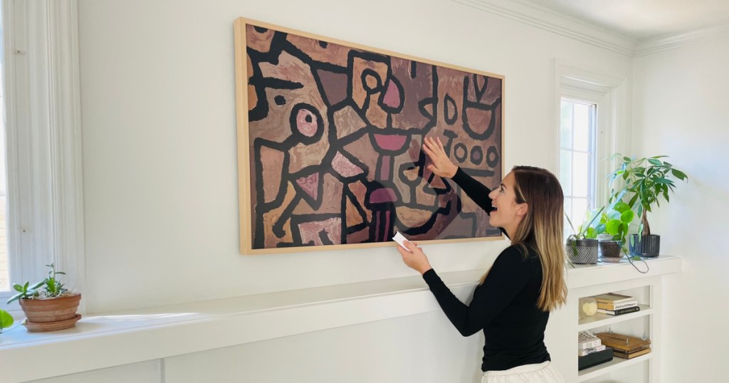 woman showing samsung the frame tv