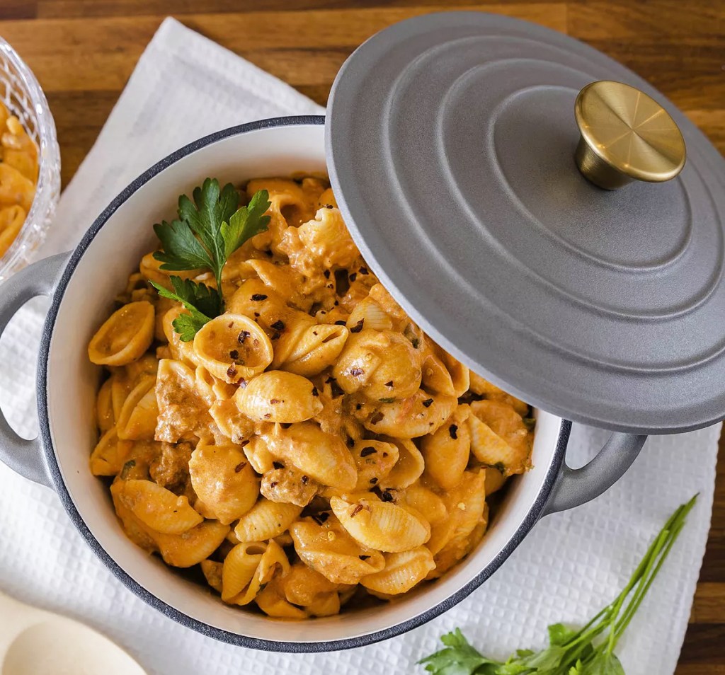 grey dutch oven with it's lid off showing pasta dish inside