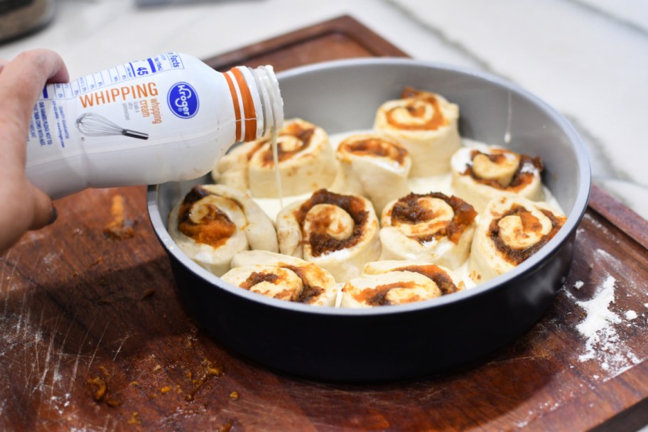 adding whipping cream to cinnamon rolls (