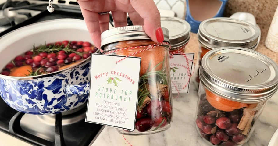 holding jar of christmas stove top potpourri