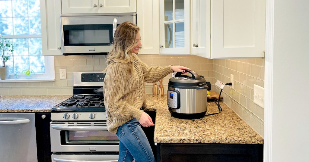 woman standing in kitchen holding lid to instant pot